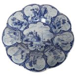 A 19th century Delft pottery cushion-shaped dish with painted panels, diameter 33cm A few tiny glaze