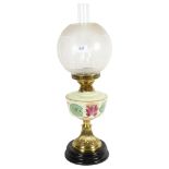 A Victorian and brass oil lamp, with etched clear glass shade and milk glass painted font, on a