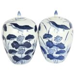 A pair of large Chinese design blue and white vases and covers, with lily decoration, height 33cm