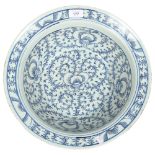 A Chinese Qing Dynasty porcelain basin or bowl, with blue and white scrolling peony decoration,