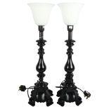 A pair of black composition table lamps with white glass shades, height 62cm