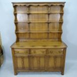 An Ercol elm 2-section dresser, with 3 fitted drawers and cupboards under, with maker's label, 145cm