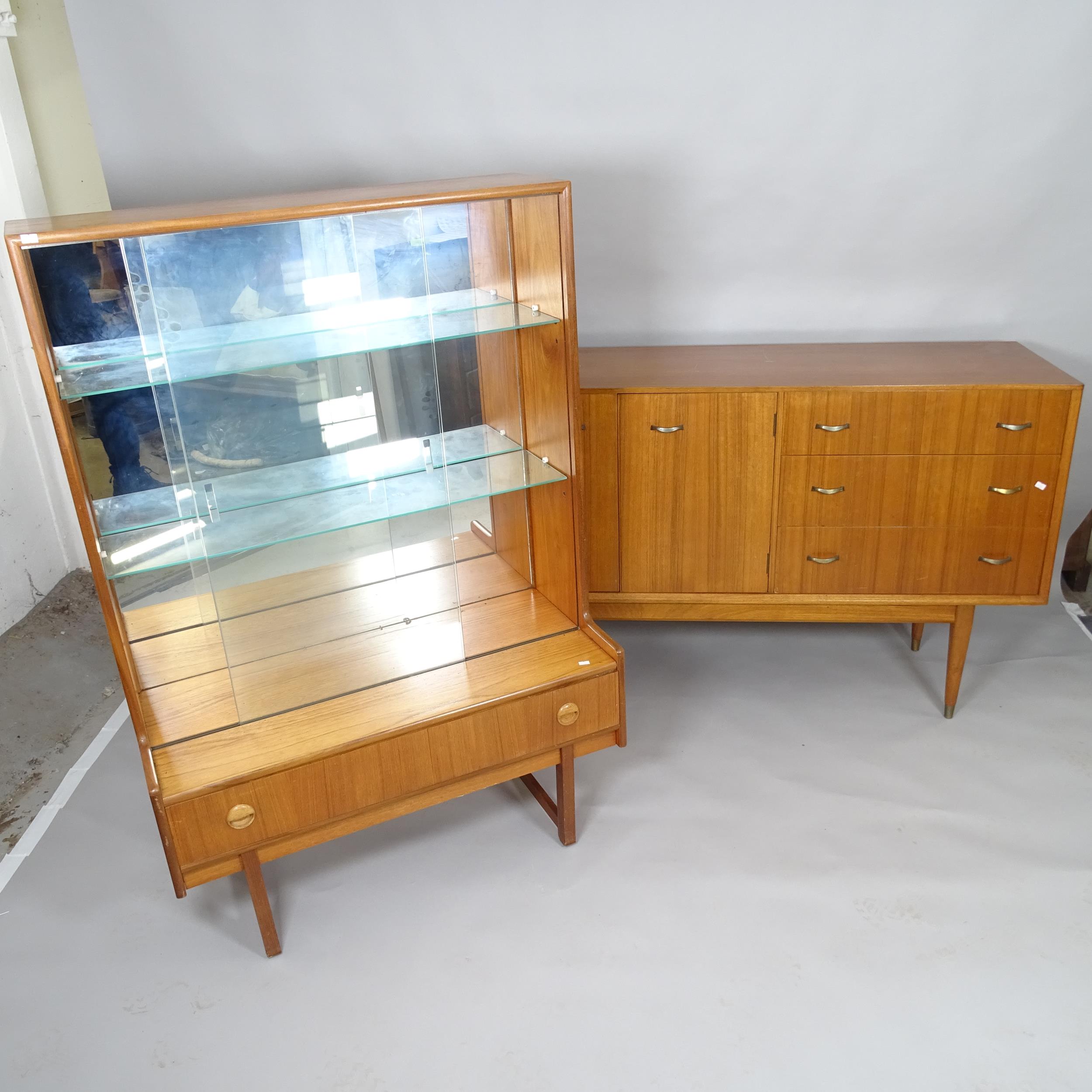 A mid century teak display cabinet with raised mirror back, two adjustable glass shelves and