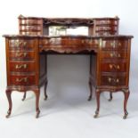 A mahogany writing desk, with tooled and embossed green leather skiver, raised mirrored back and