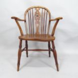 An early 19th Century elm seated wheel-back elbow chair