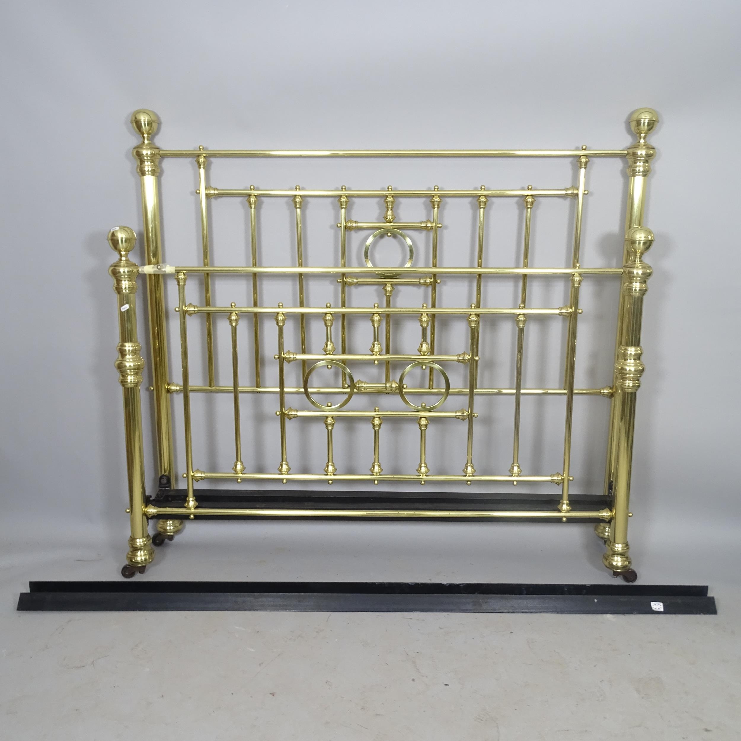 A modern brass 5' double bed, with side rails.