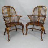 A pair of Windsor double bow arm chairs, with elm seat and crinoline stretcher