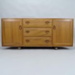 A mid-century Ercol Windsor elm sideboard, with 3 frieze drawers and panelled cupboards, 155cm x