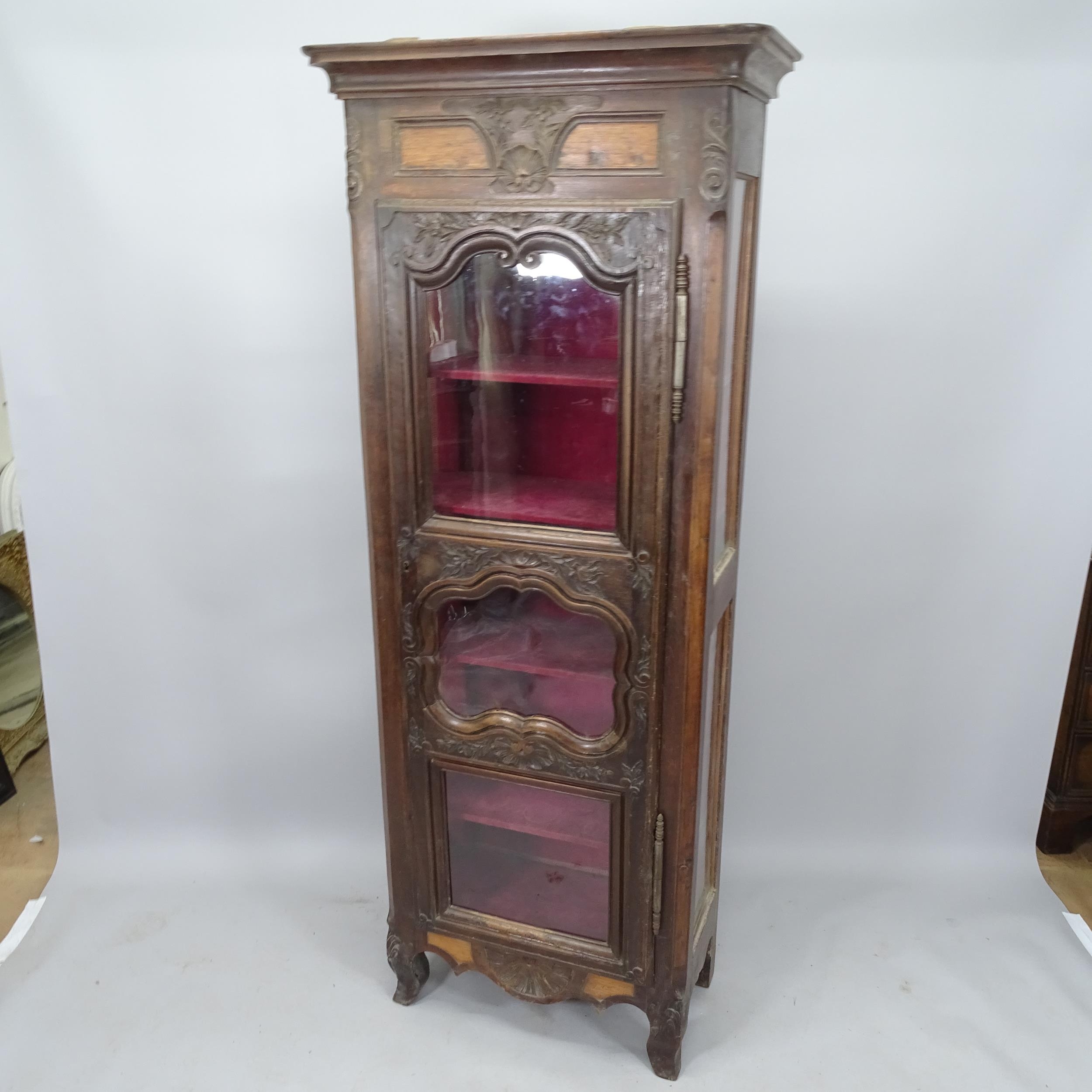 A French oak single door display cabinet, with glazed panelled sides and carved decoration, 80 x 200