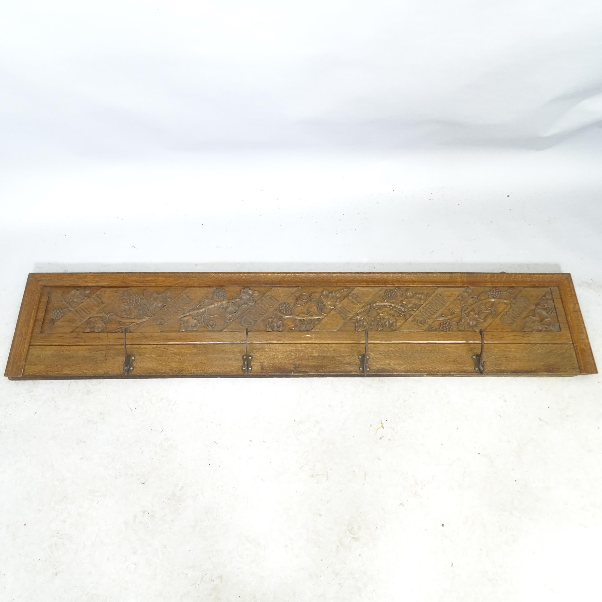 A carved oak Art Nouveau style hanging coat rack with 4 hooks, inscribed In Te Domine Confido. 153cm