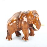 A well carved Indian honey coloured hardwood model of an elephant with chains and ivory tusks,