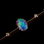 An early 20th century 9ct gold black opal bar brooch, set with oval cabochon opal, measuring 8.