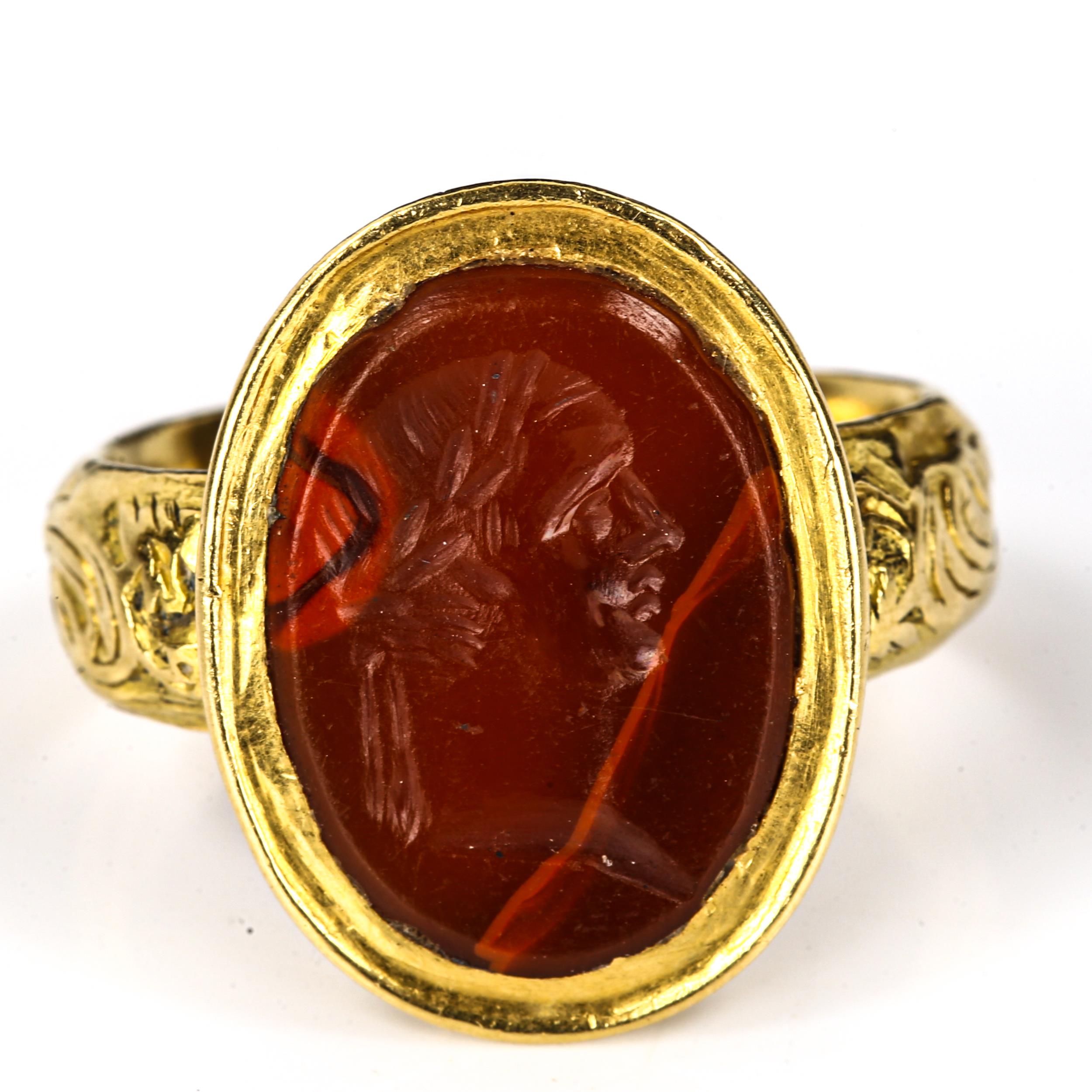 An Antique hardstone seal ring, heavy unmarked high carat gold settings, with intaglio carved male