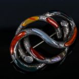 A large Scottish hardstone brooch, unmarked silver settings with overlapping swirl design and