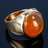 An unmarked gold carnelian signet ring, set with round cabochon hardstone, setting height 15.8mm,