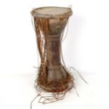 An African Tribal drum with sinew sides, height 40cm, diameter 20cm Sinews are all loose, the wood