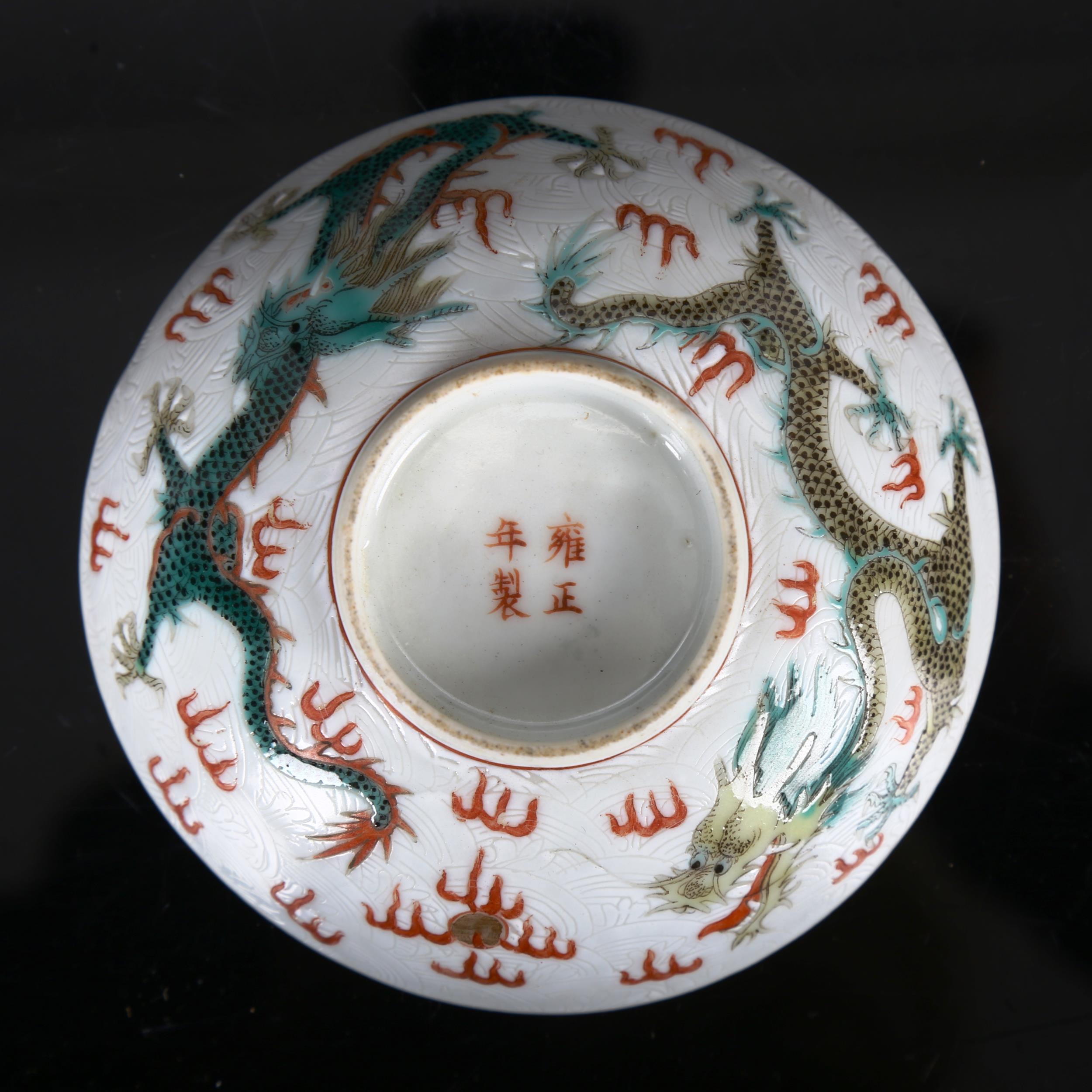 A Chinese white glaze porcelain bowl, with painted enamel dragons and pearls, 4 character mark,