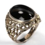 A large 1970s silver onyx ring, pierced and textured organic form shoulders, hallmarks Birmingham