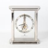 MATTHEW NORMAN - a rhodium plated Helios Skeleton 8-day mantel clock, silvered chapter ring with