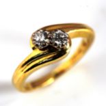 A modern 18ct gold two stone diamond crossover ring, set with modern round brilliant-cut diamonds,