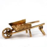 A miniature unmarked gold gardening wheelbarrow charm/pendant, length 24.3mm, 0.9g Edges have a