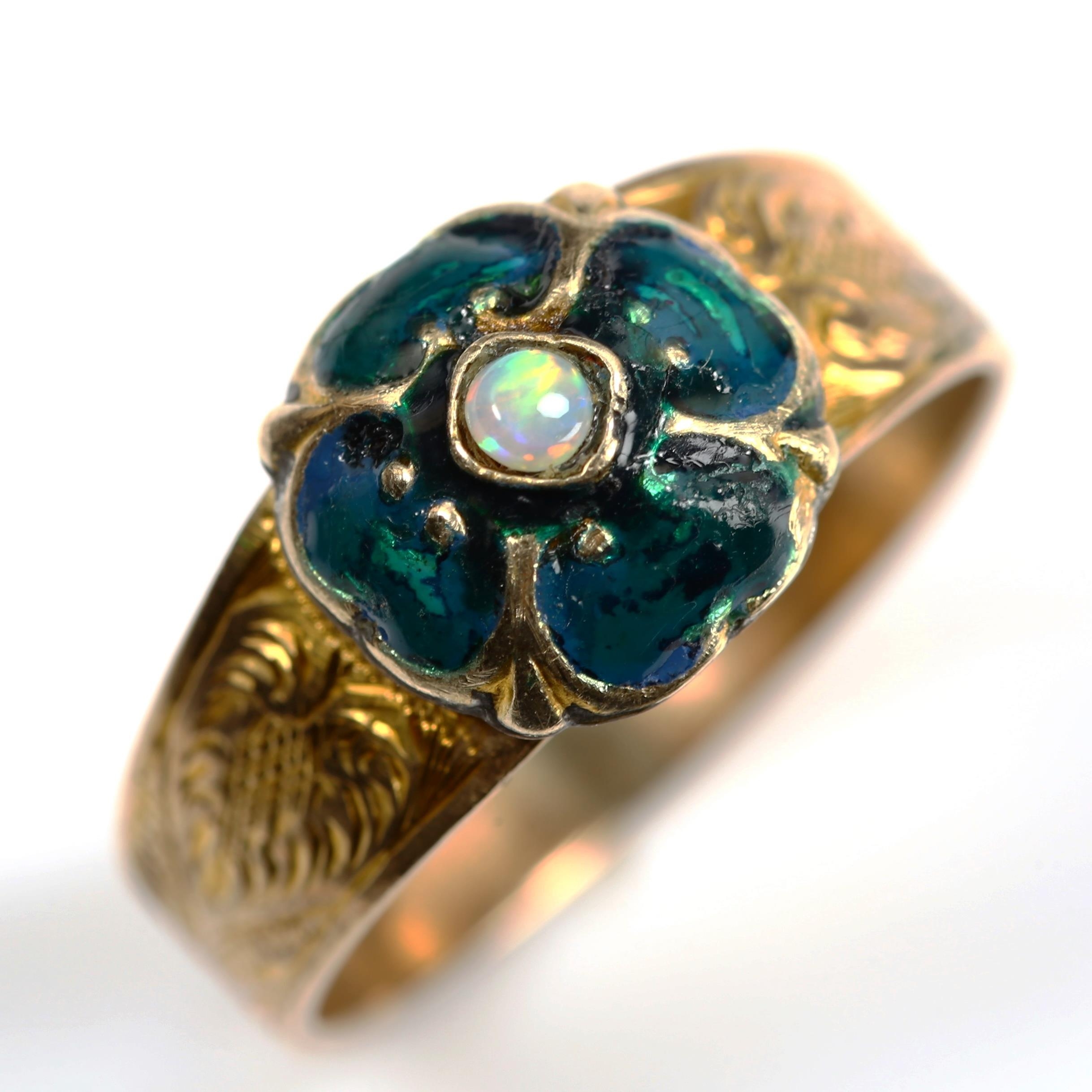 An Antique opal and enamel clover ring, unmarked gold settings with floral engraved shoulders,