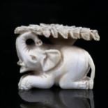 A 19th century ivory carving depicting an elephant sheltering under a tree, length 4.5cm