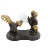 A contemporary parcel gilt and patinated bronze sculpture of fighting cockerels, on shaped marble