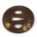 An Antique Japanese iron tsuba with parcel gilt relief vine leaves, length 6.5cm