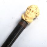 A carved ivory-handled walking cane, depicting the head of a man