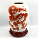 A Chinese white glaze porcelain jar with painted dragon, on hardwood stand, overall height 33cm