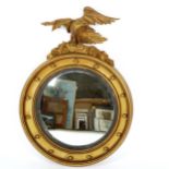 A 19th century giltwood-framed convex wall mirror, surmounted by an eagle, overall height 70cm