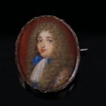 A miniature watercolour portrait a man wearing a powdered wig, in unmarked silver brooch mount,