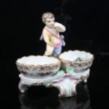 KPM porcelain table salt surmounted by a putti figure, height 12cm