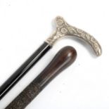 A 19th century walking stick, with unmarked white metal floral decorated handle, and a relief carved