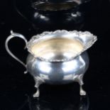 An Edwardian silver squat cream jug, with foliate rim, by Horace Woodware & Co Ltd, hallmarks London