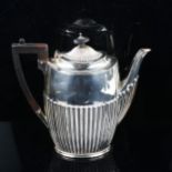 An Elizabeth II silver hot water jug, oval half fluted form with turned wood mounts, by James