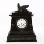 A 19th century Egyptian Revival slate-cased mantel clock with bronze mounts, surmounted by a