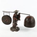 A Japanese patinated bronze pair of gongs, supported by a figure, early 20th century, height 22cm