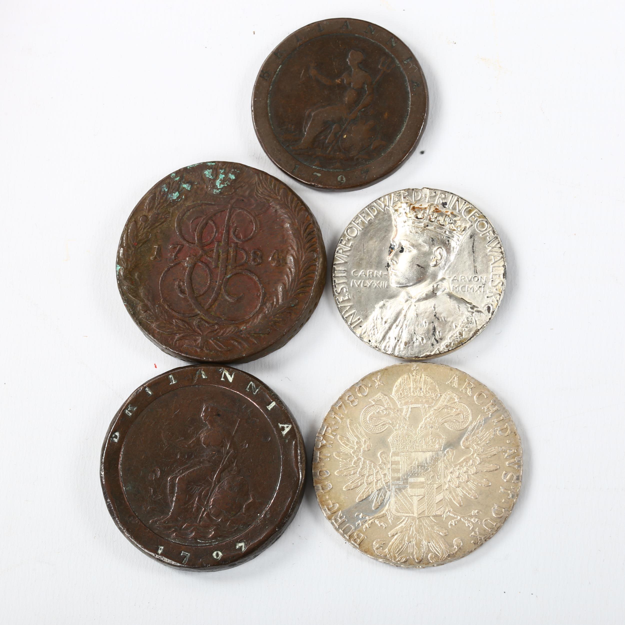 A group of coins, including an Austrian 1780 silver Thaler, 1911 Investiture coin, 1784 Russian five