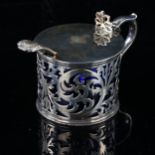 A Victorian silver drum mustard pot and spoon, pierced foliate decoration with thumb piece, blue