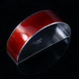 EGON LAURIDSEN - a Danish stylised sterling silver and red enamel demilune napkin ring, engine