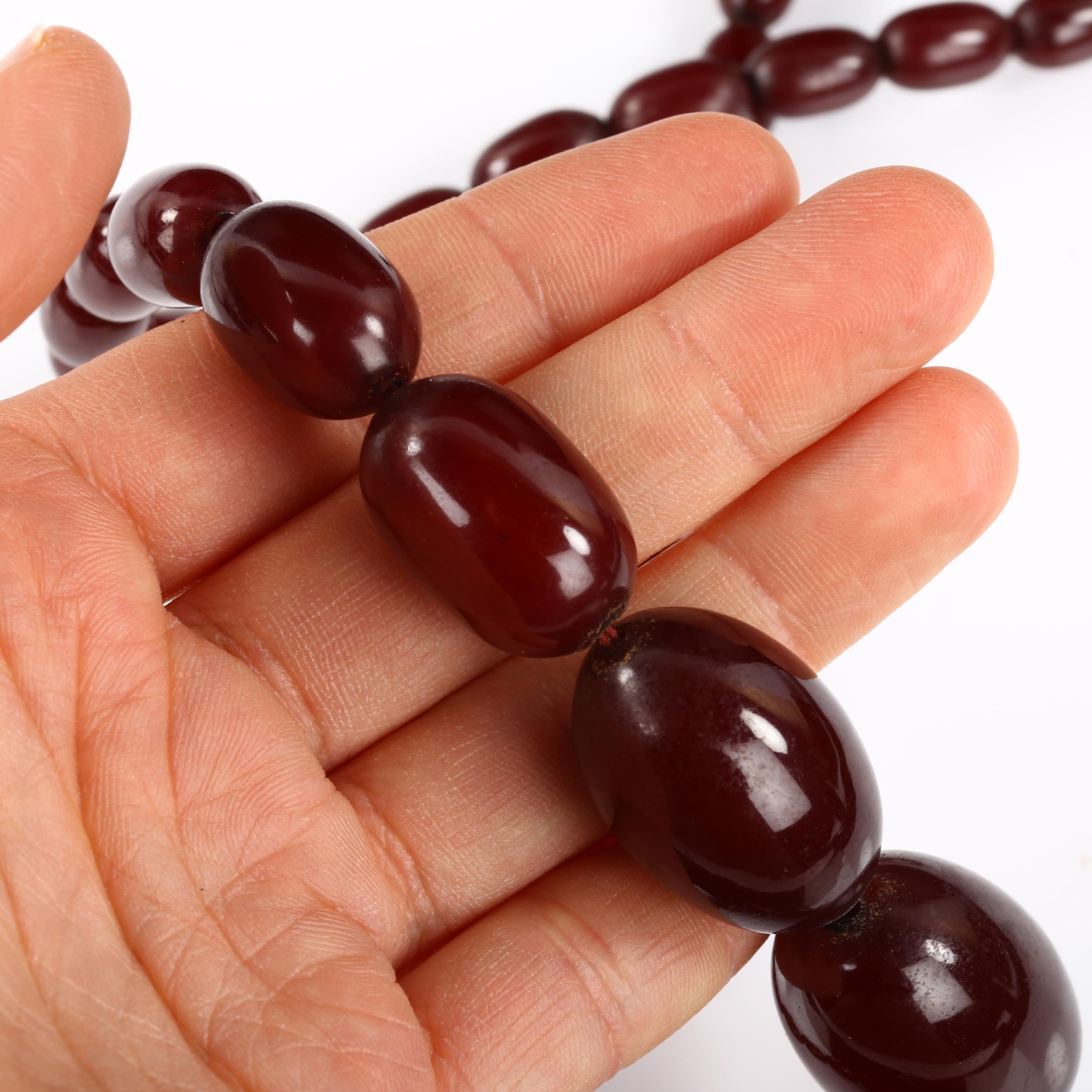 A single-strand graduated cherry amber bead necklace, bead lengths 11.5mm - 32.4mm, necklace - Image 4 of 4