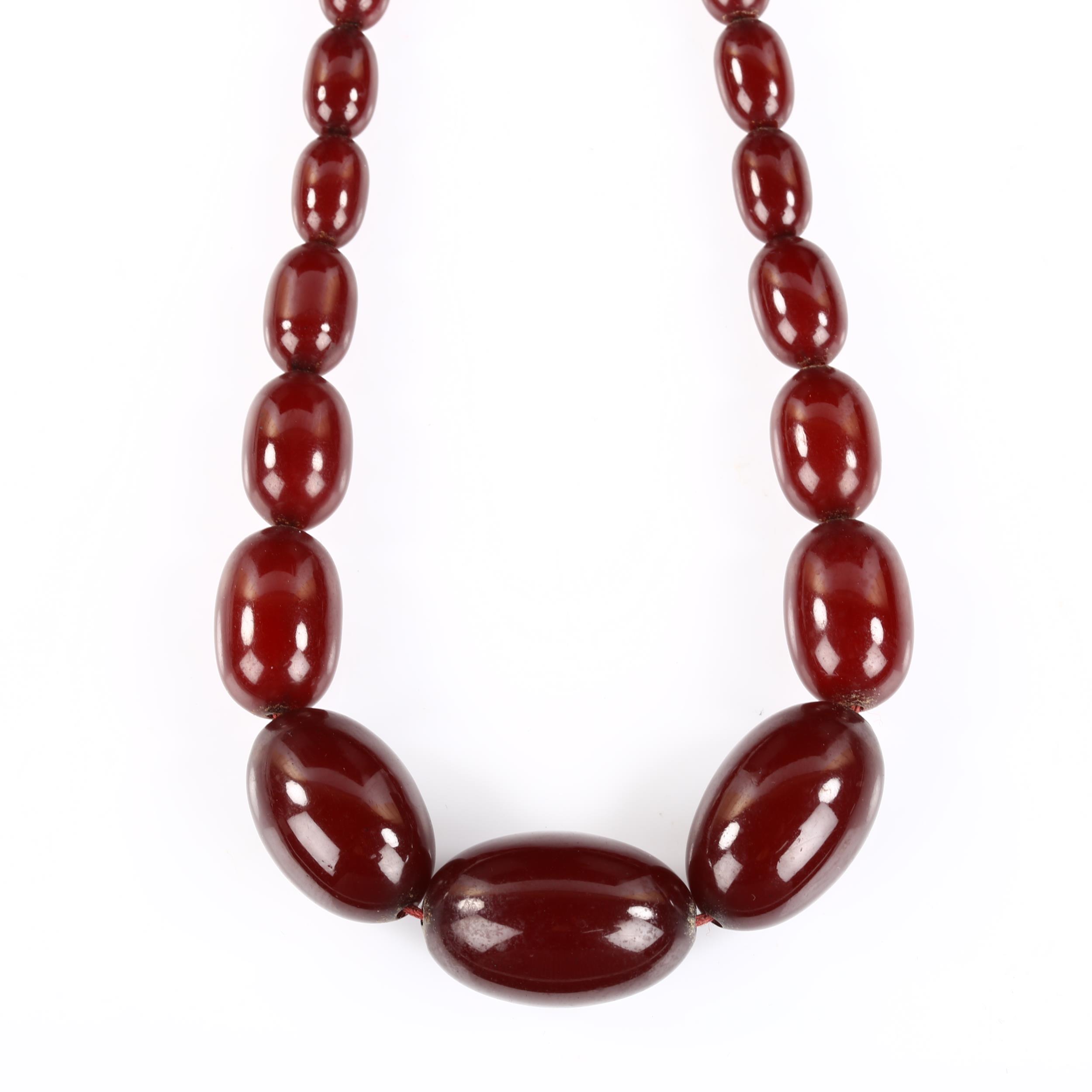 A single-strand graduated cherry amber bead necklace, bead lengths 11.5mm - 32.4mm, necklace