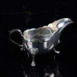 An early 20th century silver sauce boat, with scalloped rim and lion mask feet, by Williams Ltd,