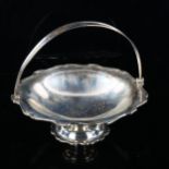 MAPPIN & WEBB - a George V silver swing-handled fruit basket, reeded scalloped rim on pedestal base,