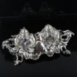 A Victorian silver Rococo style desk ink stand, with original fitted glass ink wells and pen tray,