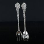 GORHAM - an American sterling silver matching sifter spoon and bread fork, cast cherub decoration,