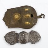 An Indian white metal buckle and another gilt brass buckle, largest 18cm long