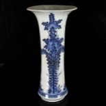 A Chinese blue and white beaker vase, 19th century, decorated in underglaze blue with floral sprays,
